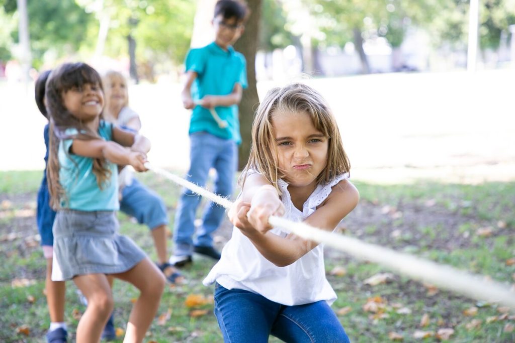 Niños jugando en equipo a tirar de la cuerda